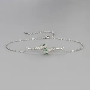 Vue détaillée du bracelet de cheville serpent strass avec texture matelassée et cristaux verts.