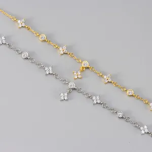 Detailaufnahme von luxuriösen Kleeblatt Zirkon Armbändern in Gold und Silber für Damen.