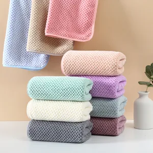 Morbido asciugamano viso in pile corallo assorbente, design a quadretti pastello per uso quotidiano.