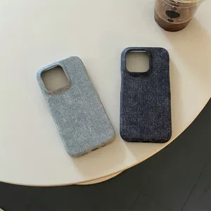 Detail view of minimalist denim phone cases in light and dark blue shades on a clean tabletop.