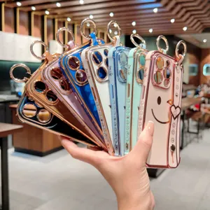 Coque iPhone électroplaquée avec dragonne et motif sourire, vue de détail colorée et stylée.
