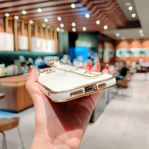 Coque de téléphone blanche électroplaquée avec cadre or rose et détail de support bracelet luxe.