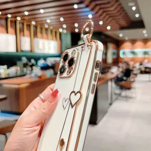 Gros plan de la coque de téléphone de luxe galvanisée cœur avec lanière et anneau.