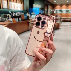 Vue détaillée de coque iPhone rose galvanisée avec dragonne souriante mignonne et cœur.