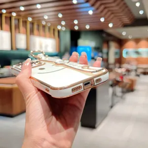 Détail de la coque de téléphone galvanisée avec motif souriant et lanière de poignet pratique.