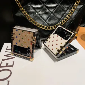 Detailansicht des luxuriösen glitzernden Herz Klapphandy-Etuis mit edlem Metalleckenschutz.