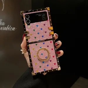 Glitzer Klapphandy Hülle Detail mit rosa Herzen Muster, goldenem Ring und Metall Ecken.
