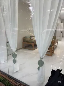 Nahaufnahme des handgeflochtenen Blatt-Vorhangraffhalters in modernem Ausstellungsraum.