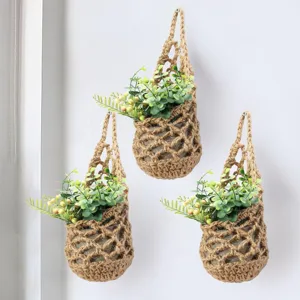 Detailed view of handmade crochet hanging net bag, bohemian wall storage basket and planter.