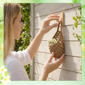 Close-up detail shot of a handmade jute crochet hanging basket mounted on a wooden wall hook.