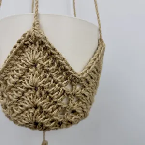 Detail van jute touw plantenhanger, boho gehaakte hangende pot net houder voor binnentuin decoratie.