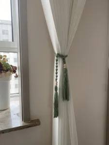 Handmade macrame curtain tieback with wooden beads and tassels, elegant bohemian style home decor.