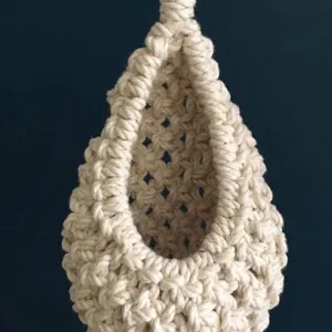 Dettaglio del gancio per piante in corda di cotone macramè fatto a mano con trama tessuta.