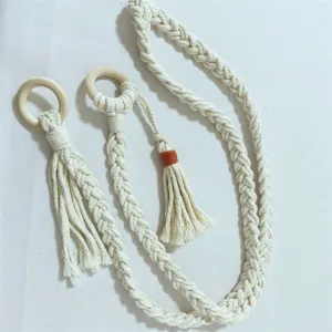 Cinturino per tappetino yoga intrecciato a mano con anelli in legno e nappe eleganti.