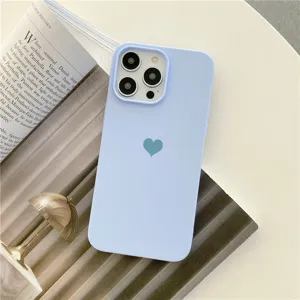 Gros plan sur la coque de téléphone en silicone bleu pastel avec motif cœur et découpe appareil.