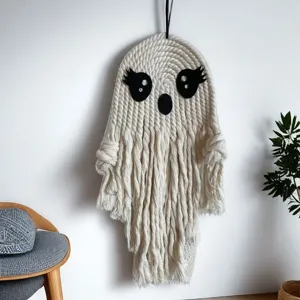 Handmade macrame ghost wall hanging, white cotton rope Halloween party decoration detail.