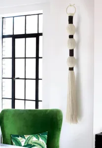 Handgemaakte katoenen linnen wandhangers met bollen en kwasten boho-stijl detail view.