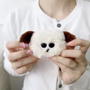 Close-up of fluffy white puppy plush AirPods case with brown ears and cute design detail view.