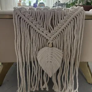 Detalle de camino de mesa de macramé bohemio hecho a mano, decoración en algodón ecológico.