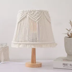 Handmade macrame table lamp detail, boho cotton woven lampshade with natural wooden base.