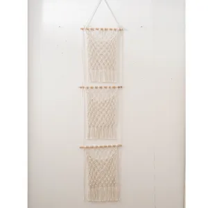 Detailed view of the handmade macrame wall hanging pocket with natural cotton cord and wood.