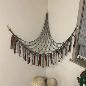 Detailed view of handmade corner toy hammock net in grey with colorful ribbons for kids room.