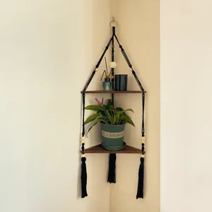 Étagère d'angle en macramé bohème avec deux plateaux en bois, support mural suspendu.