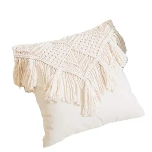 Detailed close up view of handmade woven cotton macrame tassel bohemian pillow cover.