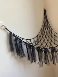 Detail view of handmade black macrame toy hammock with star tulle tassels for corner.