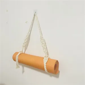 Cinghia in macrame per tappetino yoga con anelli in legno e nappe per un facile trasporto.