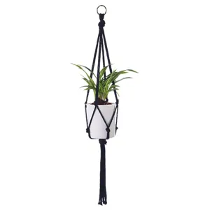 Boheemse handgemaakte macrame plantenhanger met witte pot voor stijlvolle wanddecoratie binnen.