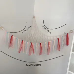 Handmade macrame toy hammock with colorful ribbons, corner plush storage net for kids room.