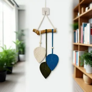 Handcrafted macrame leaf wall hanging detail showing fine cotton cord texture and natural wood branch.