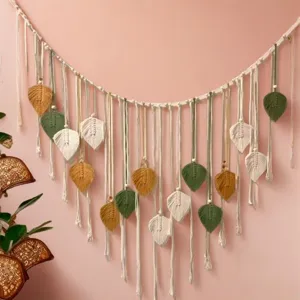 Detail view of handmade cotton macrame wall hanging with colorful leaf decor and wooden beads.