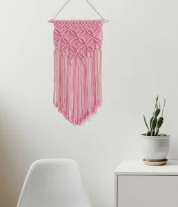 Pink handmade woven macrame wall hanging detail, boho style cotton cord home decor aesthetic.