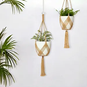 Détail de suspension pour plante en corde de coton tissé main avec un pot blanc élégant.