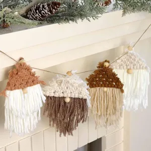 Detalle de guirlanda de gnomos de macrame hecha a mano en chimenea con pinos decorativos.
