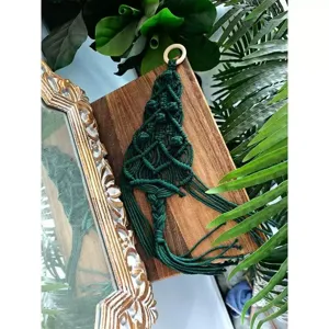Handmade dark green macrame Christmas tree wall hanging detail, boho festival home decor.