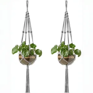 Handgemaakte macrame plantenhanger met glazen bol bloempot voor interieurdecoratie.