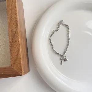 Zilveren armband met hangslot en sleutel bedel detail, minimalistische dames sieraden.