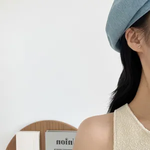 Close-up detail of minimalist silver crescent moon stud earrings worn by model. Elegant style.