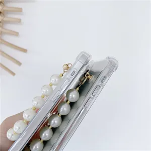 Clear phone case detail with elegant pearl wrist chain for iPhone, soft edge back cover.