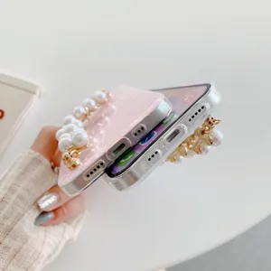 Pearl chain phone case detail view showing shell texture and acrylic finish design elements.