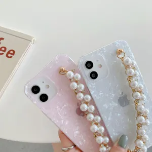 Acrylic shell pattern phone case with pearl bracelet strap, stylish and elegant protective cover.