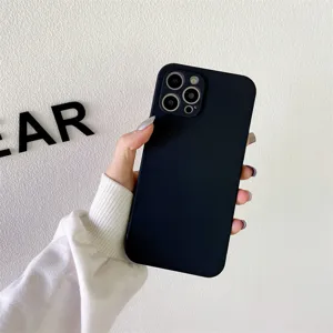 Primer plano detalle de funda de teléfono de silicona negra en mano contra pared blanca.