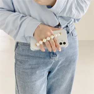 Clear phone case with elegant pearl wrist strap detail showcasing design and everyday use.