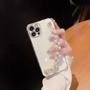 White electroplated phone case with elegant pearl chain wristband, detail view.