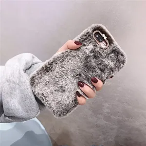 Detailed view of the plush furry phone case with rhinestones and bow accent for winter use.