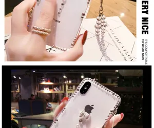 Transparent rhinestone bow phone case with beaded strap for iPhone, sparkling and protective.