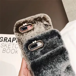 Plush phone case with sparkling rhinestone bow, soft winter furry protective cover for smartphone.